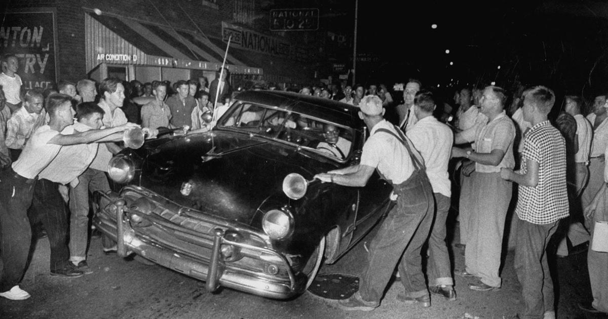 Archival photograph of a hostile crowd surrounding a Black motorist's car