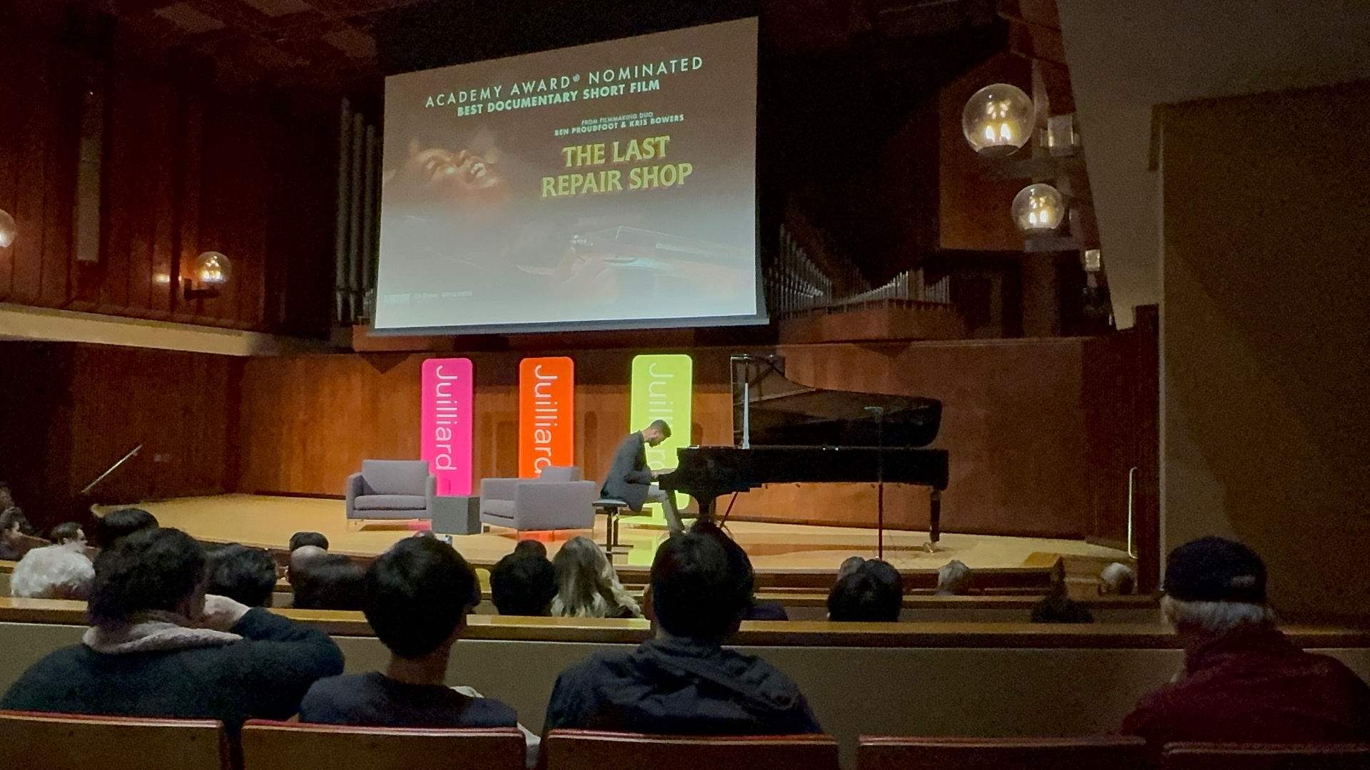 Live piano performance under The Last Repair Shop Academy Award nomination screen at Juilliard FYC event