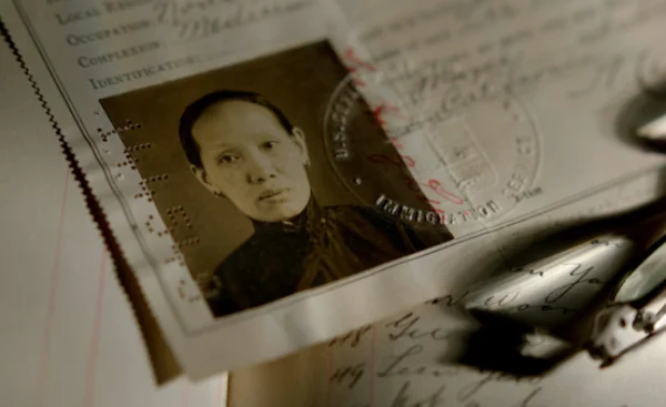 Immigration certificate photograph of a Chinese woman, with official seal and handwritten records