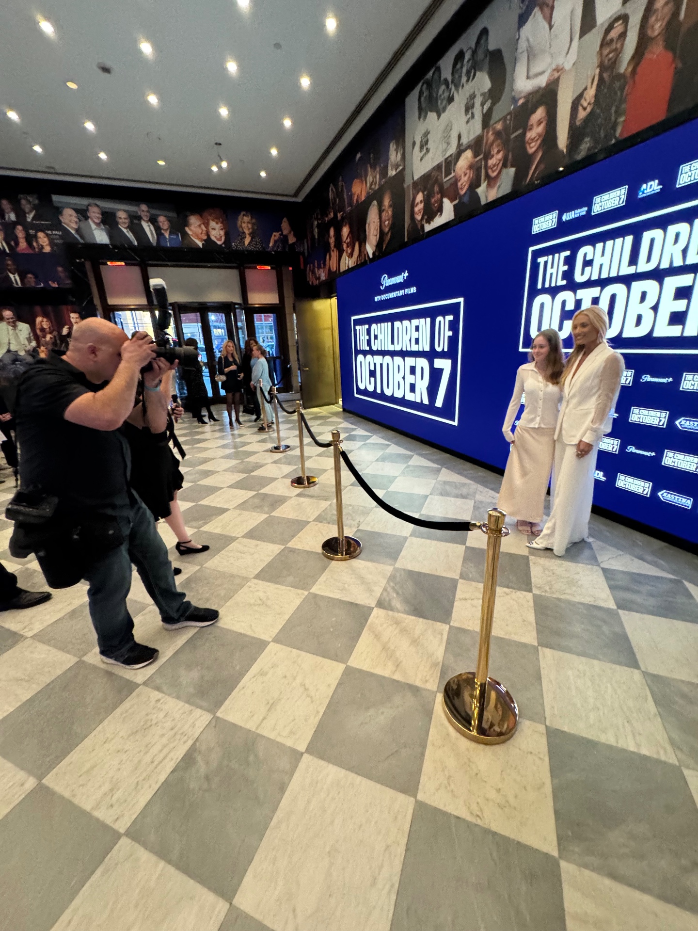 House photographer shoots talent on the step-and-repeat at The Children of October 7 premiere.
