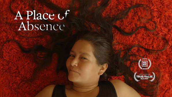 A Place of Absence — overhead shot of a woman lying on a crimson shag rug, her dark hair splayed around her